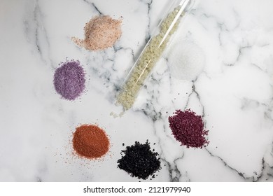 Marble counter top background with various red, pink Himalayan, purple, black and sea salts
