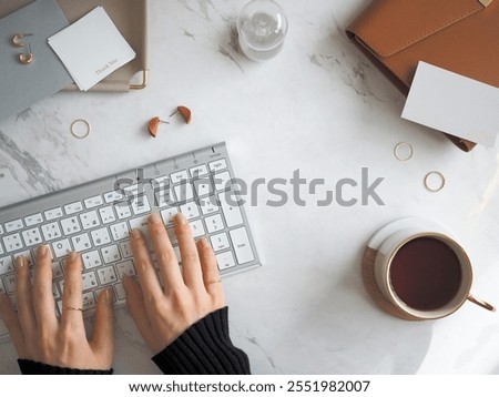 Marble flat lay top view female office computer desk, clear sleek stylish woman workspace and female hands typing   