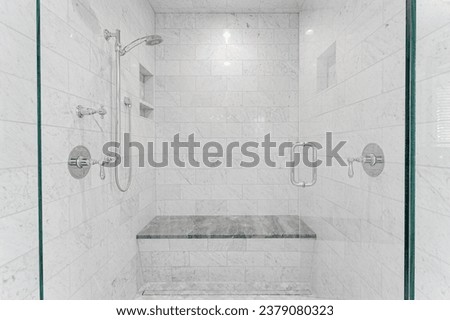 Marble Shower Interior with Chrome Fixtures, Recessed Niches, and Granite Bench, Highlighted by Soft Overhead Lighting