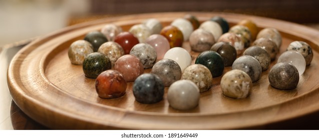 Marble Solitaire Board Game On Table. Wooden Board With Marbles For Playing Peg Solitaire.