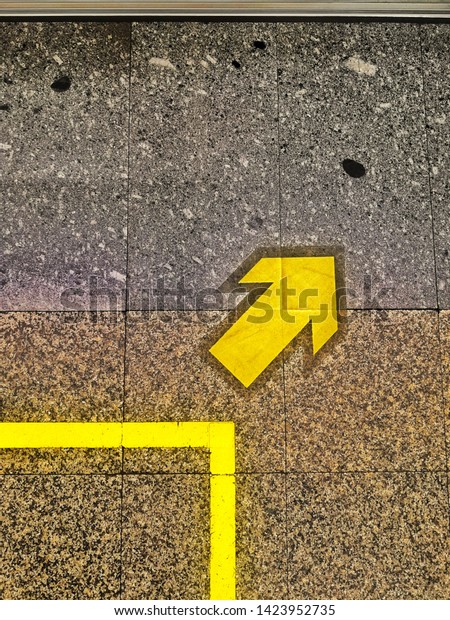 Marble striped walking floor,\
standing, waiting for car has an arrow symbol to tell the\
way