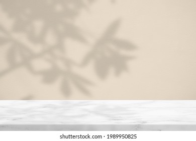 Marmortisch mit Brachen und Blättern auf Konkreter Wandtextur-Hintergrund im Sail Champagner Ton, geeignet für Kosmetische Produktpräsentation Hintergrund, Anzeige und Aufziehen.