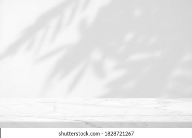 Marble Table with Leaves Shadow on Stucco Wall Texture Background, Suitable for Product Presentation Backdrop, Display, and Mock up.