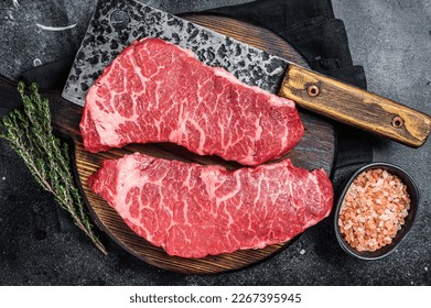 Marbled beef Denver raw meat steak with herbs. Black background. Top view. - Powered by Shutterstock