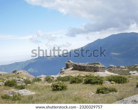 Marcahuasi chullpas, house made with stones next to the abyss, archaeological remains on the mountains with a background of blue sky with clouds