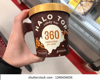 March 15, 2019 - Minneapolis, MN: Female Hand Holds A Pint Of Halo Top, A High-protein, Low Sugar, Low-calorie Ice Cream In Candy Bar Flavor At A Grocery Store