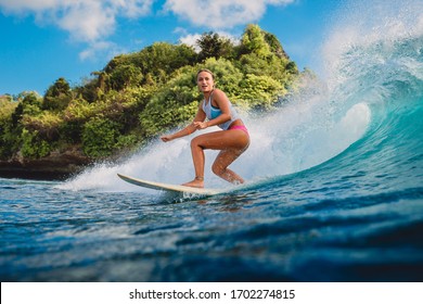 March 15, 2020. Bali, Indonesia. Surfer girl on surfboard. Woman in ocean during surfing.