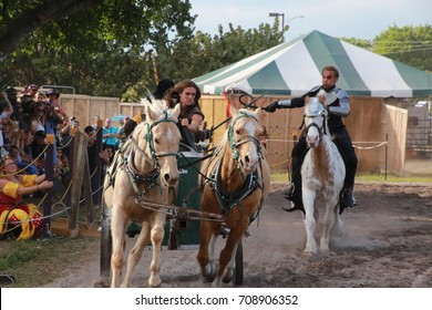 MARCH 18 2017 - RENAISSANCE FESTIVAL - DEERFIELD BEACH, FL  A Warrior Riding Horseback With A Whip Chases Other Warriors In A Horse And Carriage In Front Of Spectators.