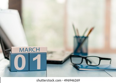 March 1st. Day 1 of month, calendar on business office background, workplace with laptop and glasses. Spring time, empty space for text