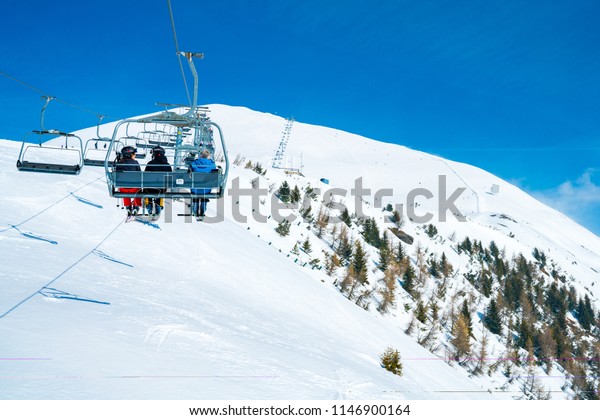 March\
20, 2018. Austria. Ski lifts and cable cars going up the mountain\
bringing snowboarders to ski slopes. Ski\
resort.