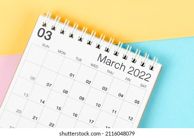 March 2022 desk calendar on multicolored background.