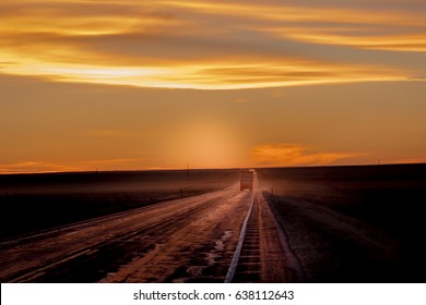 MARCH 8, 2017, NEBRASKA - Sunset Over Rural Farm Country Road With Pickup Truck Driving By Row Of Powerlines