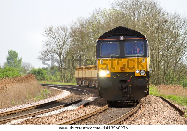 MARCH, CAMBRIDGESHIRE, UK - APRIL 30, 2014: Colas\
Rail Class 66/8 No. 66850 \'David Maidment OBE\' rounds the curve at\
March, working 607D 09:58 Hoo Junction Up Yard to Whitemoor\
engineer\'s train.