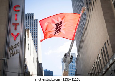 March For Our Lives: A Protester Passing Radio City Music Hall Holds A Sign In The Shape Of A Gun With A Red Flag That Says BAN At The March On 6th Ave To End Gun Violence, NEW YORK MAR 24 2018.