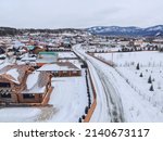 March in the village of Mansky, the snow began to melt, wooden cottages, photo from quadcopter