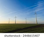 Marchfeld in Lower Austria at sunrise with wind turbines and a blue sky in spring in Austria.