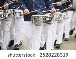 Marching band with men playing drums and wearing uniforms