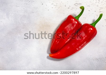 Marconi peppers atop white textured backdrop, top view, copy space. Capsicum annuum fruits