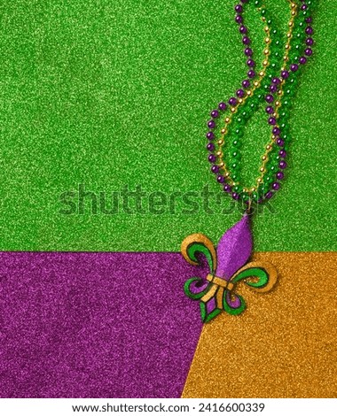 Mardi Gras beads with Fleur de lis, in glittering green, purple, and gold. Sparkling festive background for Mardi Gra in traditional colors.