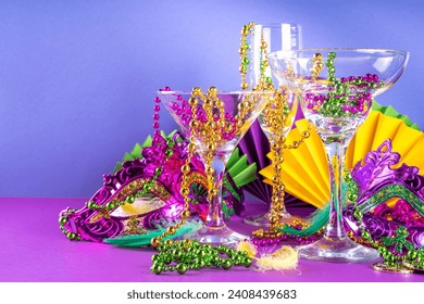 Mardi gras cocktails set. Colorful purple, yellow, green martini champagne wine cocktail glasses for Mardi gras party bar with carnival decor and orleans masquerade masks - Powered by Shutterstock