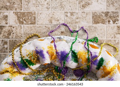 Mardi Gras: King Cake With Beads And Tile Background
