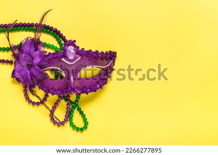 Mardi gras lettering. Congratulation card with violet mask on yellow background Top view 2023 Mardi Gras Parade Schedule Mockup Copy space