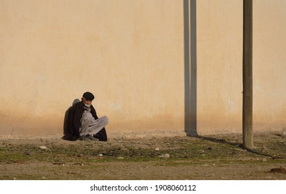 Mardin, Turkey - 12.19.2015; Old Man Sunbathing In Front Of The Wall