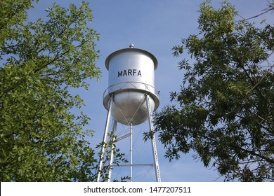 Marfa, Texas water tower with blue sky and trees