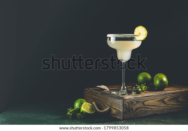 Margarita cocktail with lime and ice on minton\
dark wooden table with amazing backlight, copy space. Classic\
Margarita or Daiquiry\
Cocktail.
