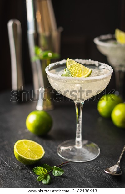 Margarita\
cocktail with lime and ice on dark wooden table with copy space.\
Classic Margarita and Daiquiri\
Cocktail.