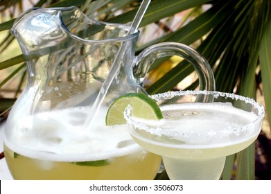 Margarita With Salt And Lime With Pitcher And Palm Tree In Background.