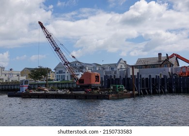 Margate City, New Jersey - September,2021: A large crane is seen on a barge on a bay near where a sea wall is being renovated