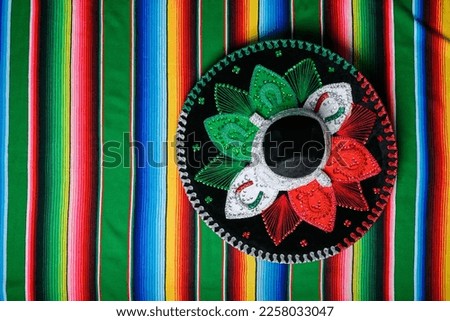 Mariachi hat with the colors of the Mexican flag on a colorful serape. Mexican sombrero.