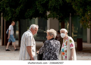 MARIBOR, SLOVENIA - SEPTEMBER 16, 2021: Selective Blur On Old Woman Discussing With Friends Wearing A Facemask,  In Street Of Maribor During Coronavirus Covid 19  Crisis.



