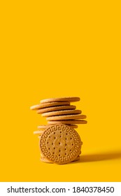 Marie biscuits stuck on bright yellow background. Modern cookies concept. 