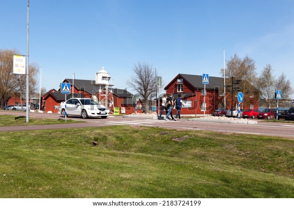 MARIEHAMN, ALAND ON MAY 07. View from a\
small town by the sea on May 07, 2016 in Mariehamn, Aland.\
Unidentified people cross the road. Beacon and red\
buildings.