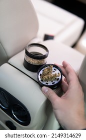 Marijuana Bud Flowers Of Cannabis. Grinder And Shredded Cannabis In Grinder Joint And A Packet Of Weed On A Car Background Close Up