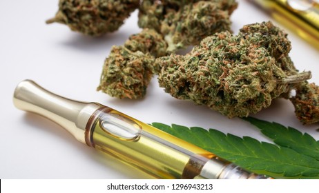 Marijuana buds closeup with cannabis oil vape and leaf.