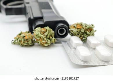 Marijuana Buds, Pills And Black Gun Isolated On White Background (drug Trafficking Concept)