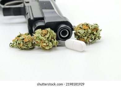 Marijuana Buds, Pills And Black Gun Isolated On White Background (drug Trafficking Concept)