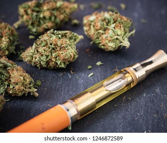 Marijuana buds with a THC oil concentrate filled vape pen