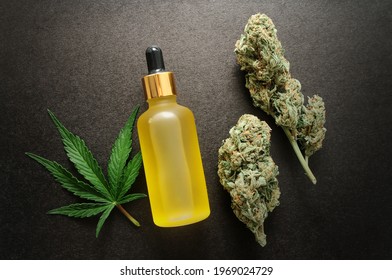 Marijuana extract in cosmetology. Cannabis blooms, cbd oil, organic cosmetics. Flat lay, black background. Home relaxation, spa recreation, pastime therapy.