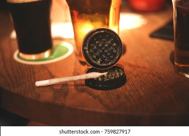 Marijuana Joint Grinder On Wooden Background In Coffee Shop Blooming Head Of Weed Cannabis Marijuana