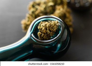 Marijuana smoking pipe CBD and THC on buds in cannabis. Macro Cannabis buds weed on black wood background. Marijuana grinder Fresh marihuana. Cannabis legalisation.