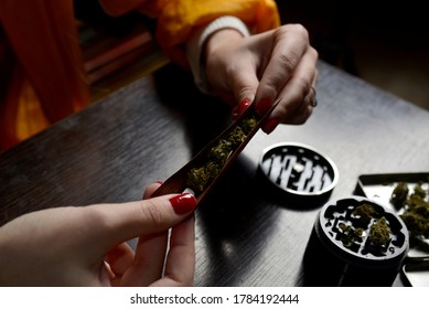 Marijuana weed young woman life style roll joint blunt cigarrette smoking woman face mask pandemic lighter