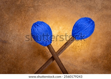 marimba mallets against backlit drum goat skin
