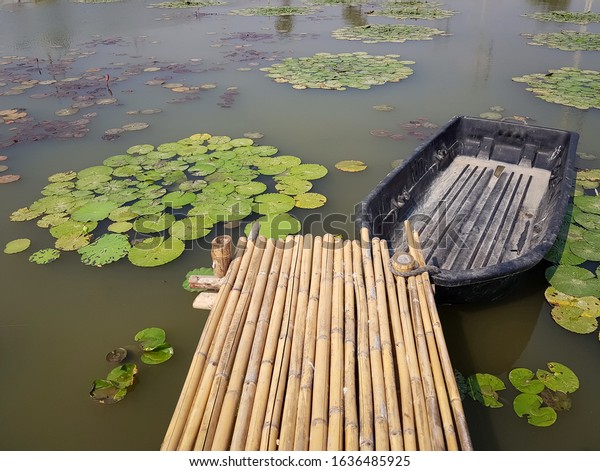 A marina made of\
bamboo in a lotus pond.