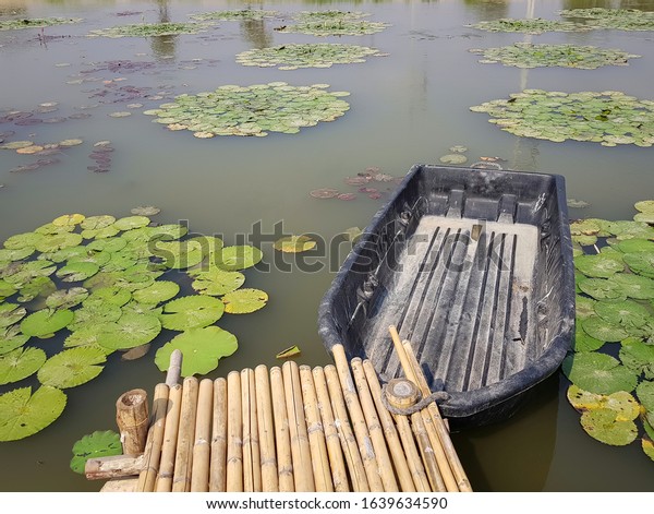 A marina made of\
bamboo in a lotus pond.