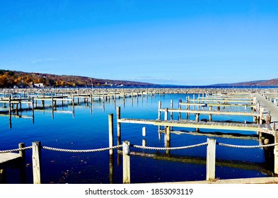 Marina On Seneca Lake, One Of Finger Lakes In New York. Transition From Autumn To Winter, So End Of Sailing Season. Boat Dockage Overview In Blue Water And Blue Sky, With Mountains Hills Surrounded 