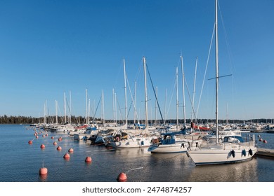 Marina sea port, sailboats moored at the dock and reflected in the sea, harbor, sea and blue sky, sunny day in Finland - Powered by Shutterstock